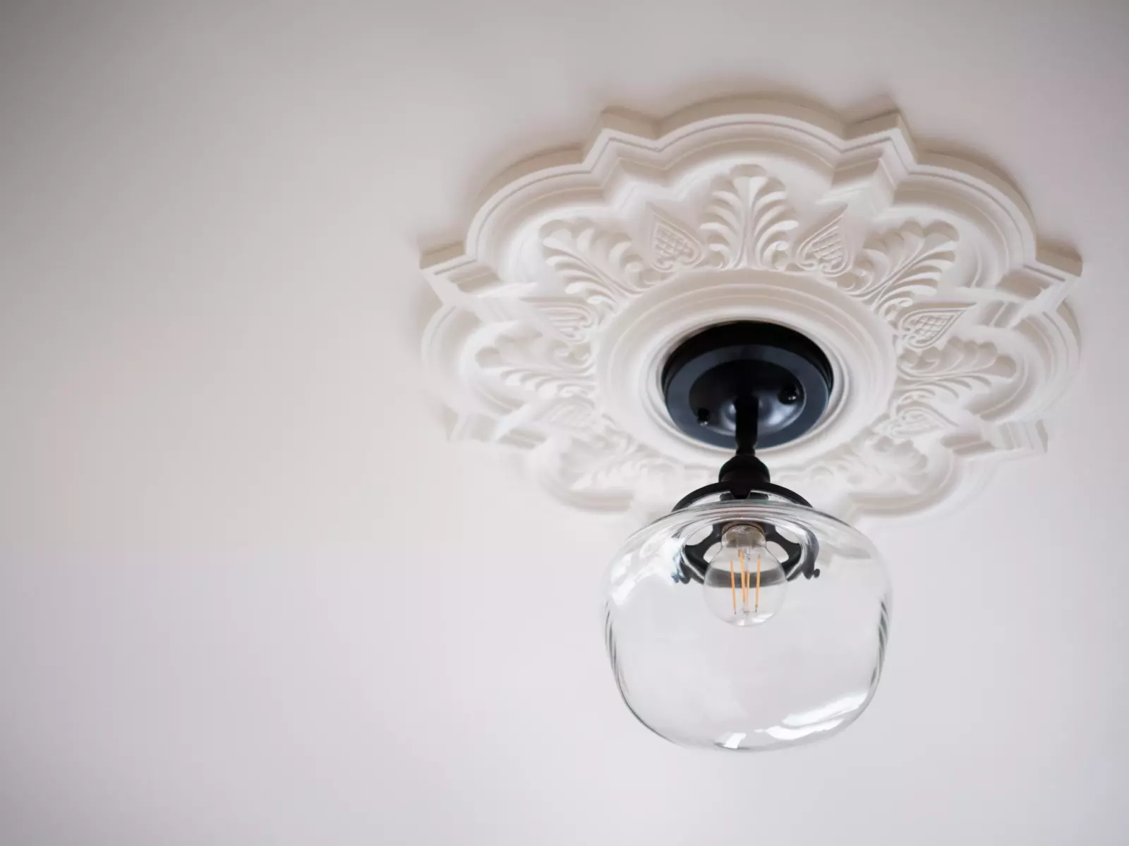 Rosace de plâtre ouvragée peinte en blanc et suspension en verre