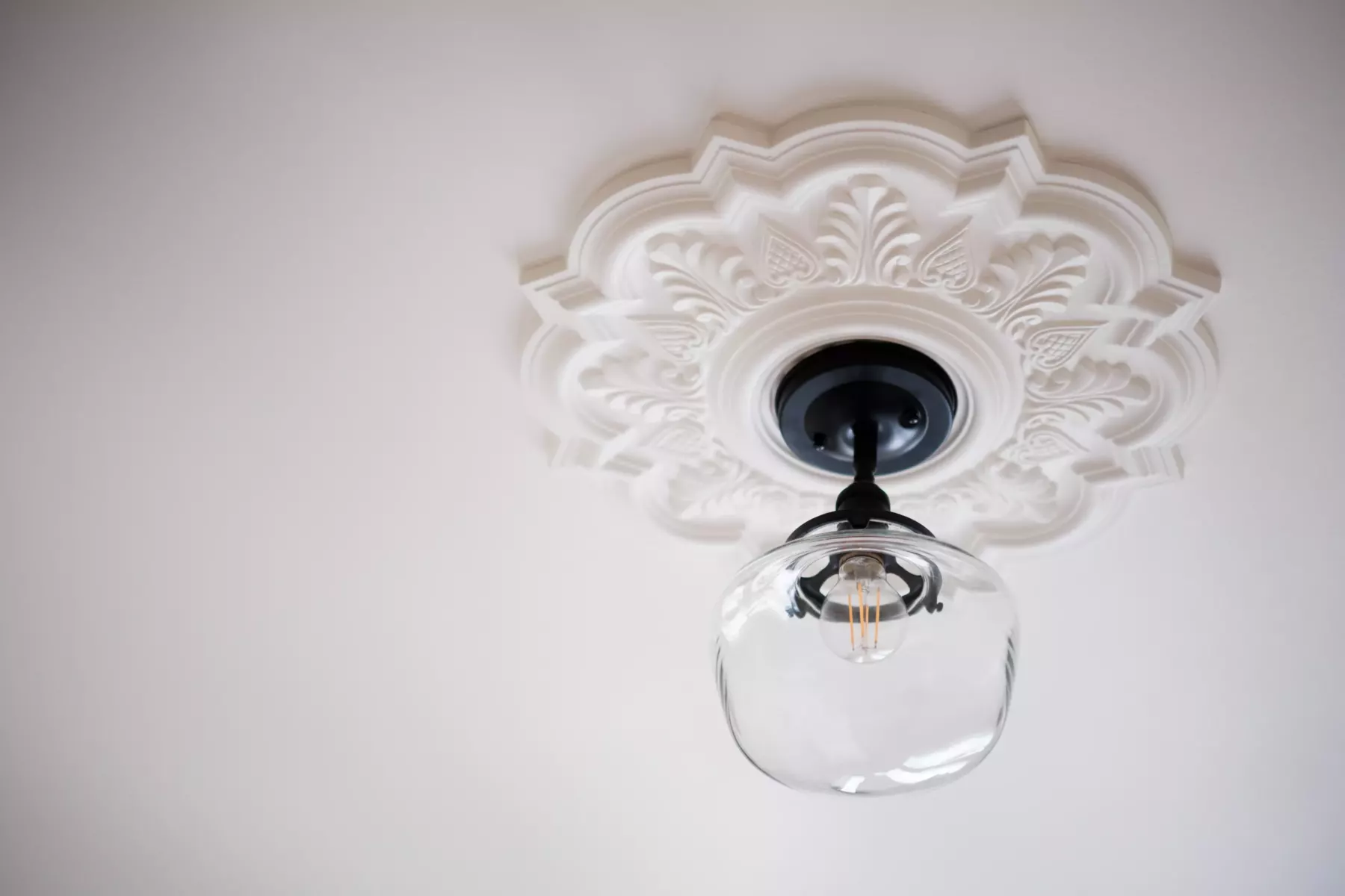 Rosace de plâtre ouvragée peinte en blanc et suspension en verre