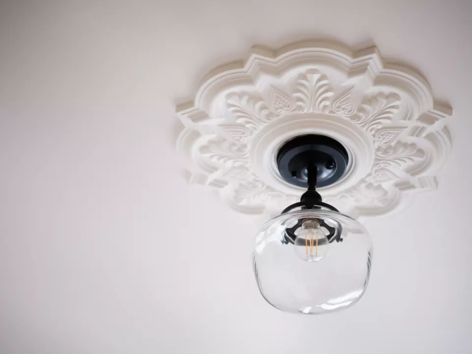 Rosace de plâtre ouvragée peinte en blanc et suspension en verre