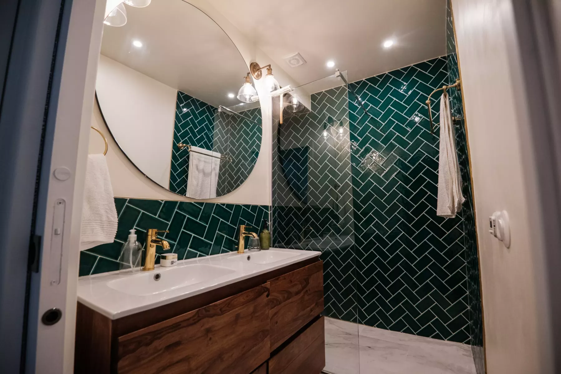 Salle de bain rénovée, faïence verte à chevrons et plafond peint en blanc