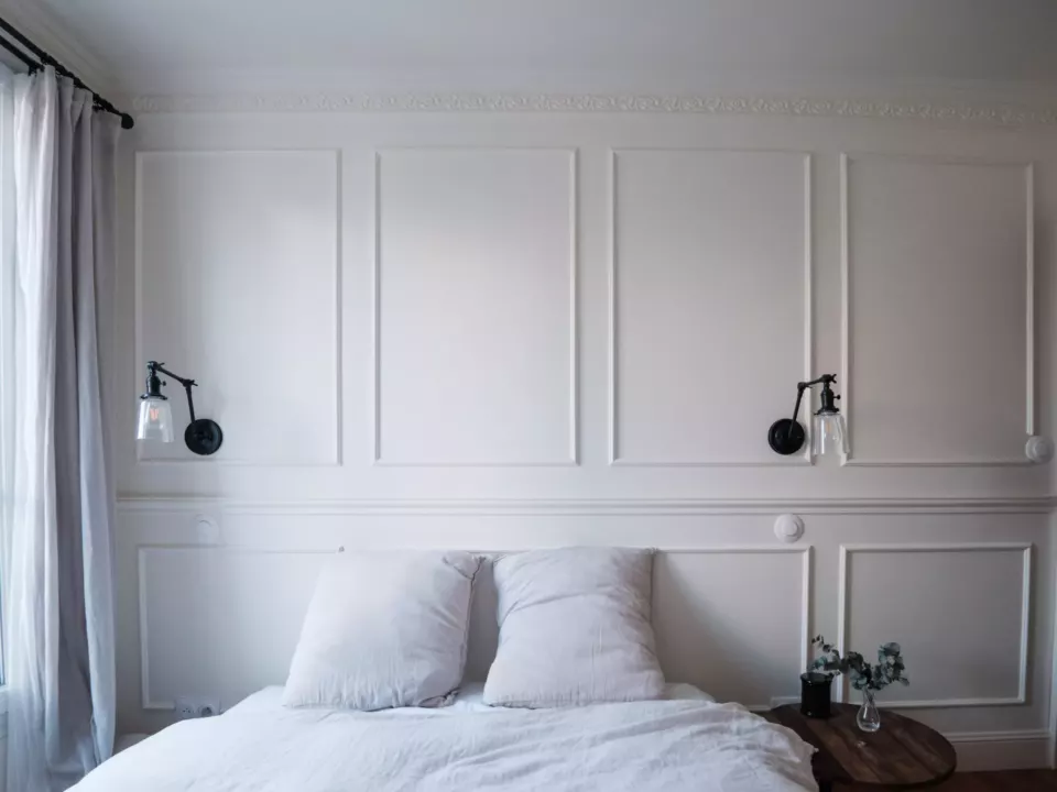 Chambre aux murs à moulures peints en blanc